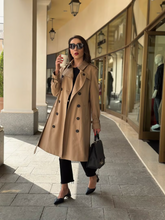 A woman wears a worsted wool trench coat